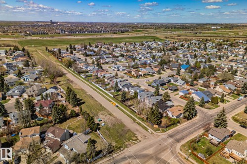 Aerial perspective showcasing a residential development with individual properties, mature trees, and paved streets - 18903 70 Avenue, Edmonton, AB - Outdoor With View
