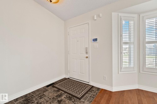 Entryway featuring a white paneled door with brushed nickel hardware, and an overhead flush-mount light fixture - 18903 70 Avenue, Edmonton, AB - Indoor Photo Showing Other Room