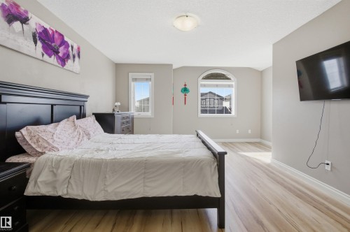 Spacious room featuring light wood-finish flooring, neutral wall tones, and white baseboards - 16204 48 Street, Edmonton, AB - Indoor Photo Showing Bedroom