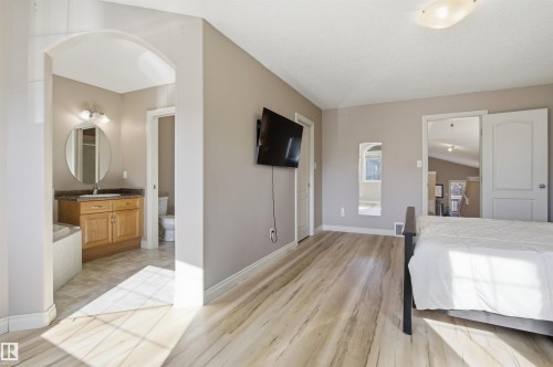 Spacious bedroom featuring light wood-finish flooring and neutral wall tones - 16204 48 Street, Edmonton, AB - Indoor Photo Showing Bedroom