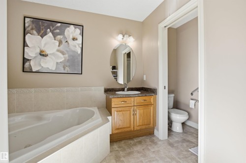 Built-in soaking tub with tiled surround - 16204 48 Street, Edmonton, AB - Indoor Photo Showing Bathroom