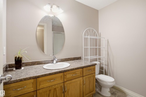 Bathroom featuring a wood-finish vanity with a built-in sink and a patterned countertop - 16204 48 Street, Edmonton, AB - Indoor Photo Showing Bathroom