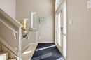 Front entry featuring a full-light door with transom window, light-toned wood-finish flooring, and a staircase with white balusters - 16204 48 Street, Edmonton, AB  - Indoor Photo Showing Other Room 