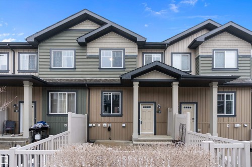 The property features a multi-toned exterior with horizontal and vertical siding, complemented by dark trim and white window frames - 90 3305 Orchards Link Link, Edmonton, AB - Outdoor With Facade