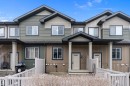 The property features a multi-toned exterior with horizontal and vertical siding, complemented by dark trim and white window frames - 90 3305 Orchards Link Link, Edmonton, AB  - Outdoor With Facade 