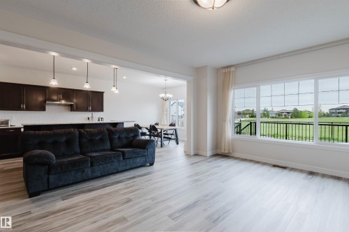 Expansive living area featuring light wood-finish flooring, large windows, and an open concept layout - 17718 5A Avenue, Edmonton, AB - Indoor Photo Showing Other Room