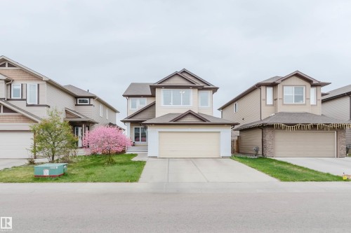 Two-story residence featuring light-colored siding with contrasting brown trim, an attached two-car garage, and a concrete driveway - 17718 5A Avenue, Edmonton, AB - Outdoor With Facade