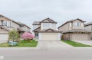 Two-story residence featuring light-colored siding with contrasting brown trim, an attached two-car garage, and a concrete driveway - 17718 5A Avenue, Edmonton, AB  - Outdoor With Facade 