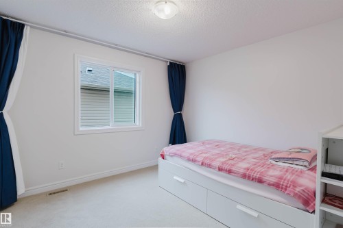 Room featuring light-colored carpet flooring, white baseboards, and a white ceiling - 17718 5A Avenue, Edmonton, AB - Indoor Photo Showing Bedroom