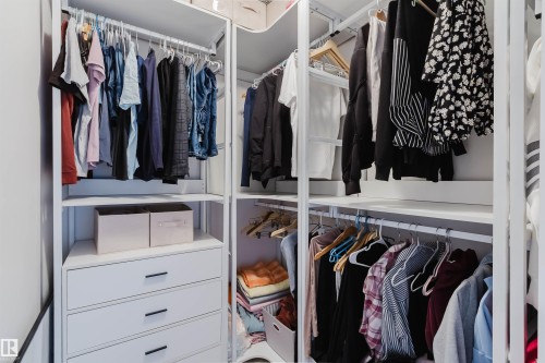 Custom closet system featuring white shelving and integrated drawers with dark hardware - 17718 5A Avenue, Edmonton, AB - Indoor With Storage