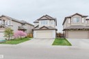 Two-story residence featuring light-colored siding with contrasting brown trim accents and a concrete driveway - 17718 5A Avenue, Edmonton, AB  - Outdoor With Facade 