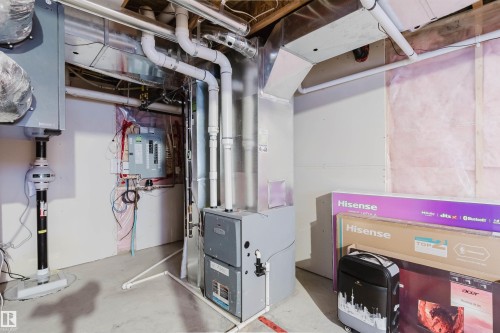 Basement utility area featuring exposed white PVC piping, metal ductwork, and a central heating unit - 17718 5A Avenue, Edmonton, AB - Indoor Photo Showing Basement