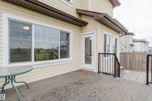 Exterior patio featuring a concrete surface, black metal railings, and a wood privacy fence - 17718 5A Avenue, Edmonton, AB - Outdoor With Exterior