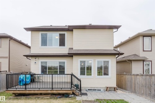 Rear exterior featuring light-colored siding and a brown shingle roof - 17718 5A Avenue, Edmonton, AB - Outdoor With Exterior