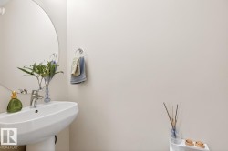 Pedestal sink with chrome faucet, large circular mirror, and chrome towel ring - 