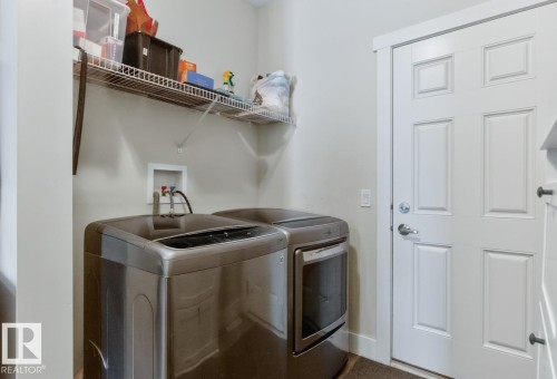 Laundry area featuring a wire shelf, utility hookups, and a paneled white door with chrome hardware - 7942 Erasmus Crescent, Edmonton, AB - Indoor Photo Showing Laundry Room