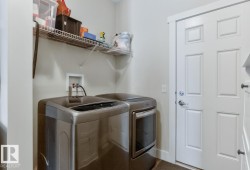 Laundry area featuring a wire shelf, utility hookups, and a paneled white door with chrome hardware - 