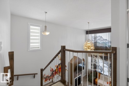 Staircase featuring wood handrails and white balusters - 7942 Erasmus Crescent, Edmonton, AB - Indoor Photo Showing Other Room