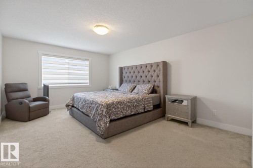 Carpeted bedroom with a single window featuring horizontal blinds - 7942 Erasmus Crescent, Edmonton, AB - Indoor Photo Showing Bedroom