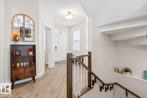Entryway with wood-finish flooring, a white paneled entry door with sidelights, and a classic flush mount light fixture - 7942 Erasmus Crescent, Edmonton, AB - Indoor Photo Showing Other Room