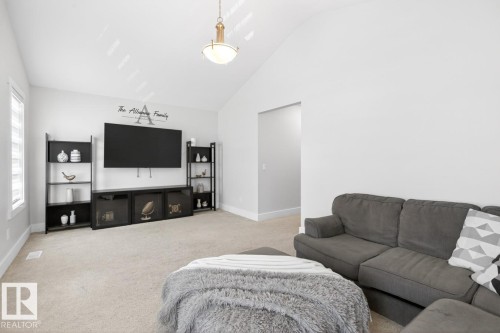Spacious living area featuring a vaulted ceiling and light-colored carpeting - 7942 Erasmus Crescent, Edmonton, AB - Indoor Photo Showing Living Room