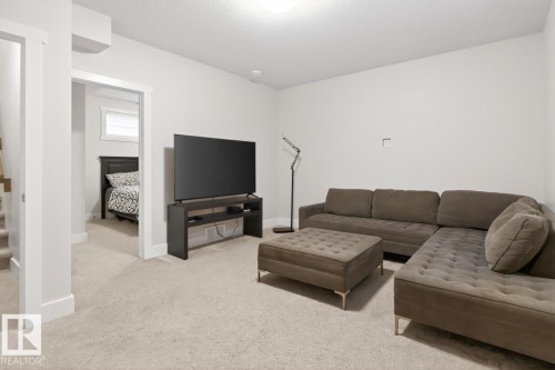 Carpeted living area featuring light-toned walls, white trim, and recessed lighting - 7942 Erasmus Crescent, Edmonton, AB - Indoor Photo Showing Living Room