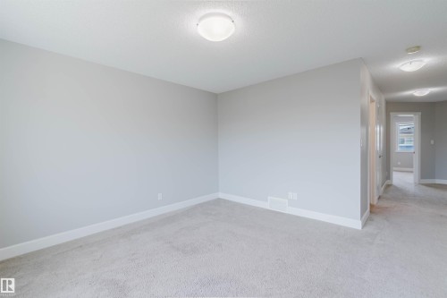 Carpeted interior space with light gray walls, white baseboards, and a flush mount ceiling light - 2839 Koshal Crescent, Edmonton, AB - Indoor Photo Showing Other Room