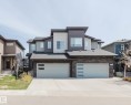 Modern multi-level facade featuring vertical and horizontal siding, stone accents, and a two-car garage with frosted glass panel inserts - 2839 Koshal Crescent, Edmonton, AB  - Outdoor With Facade 