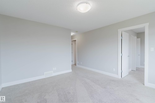 Spacious room featuring light grey walls, white trim, light-colored carpet, and a ceiling-mounted light fixture - 2839 Koshal Crescent, Edmonton, AB - Indoor Photo Showing Other Room