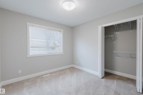 Bedroom featuring neutral-toned walls, carpeted flooring, a window with blinds, and a closet with wire shelving - 2839 Koshal Crescent, Edmonton, AB - Indoor Photo Showing Other Room