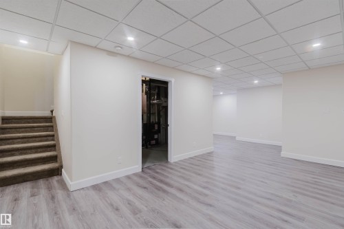 Finished basement featuring light wood-finish flooring, recessed lighting, drop ceiling, and a carpeted staircase - 2839 Koshal Crescent, Edmonton, AB - Indoor Photo Showing Other Room