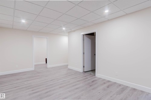 Spacious interior room featuring light wood-finish flooring, recessed lighting, and a white grid ceiling - 2839 Koshal Crescent, Edmonton, AB - Indoor Photo Showing Other Room