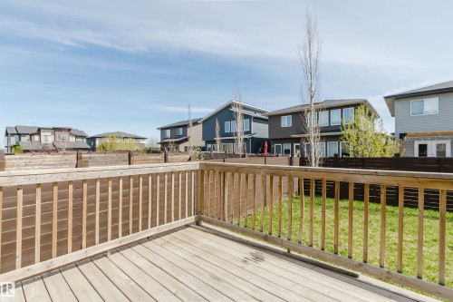 Spacious outdoor deck with natural wood railing and decking, overlooking a fenced backyard with green lawn - 2839 Koshal Crescent, Edmonton, AB - Outdoor With Deck Patio Veranda