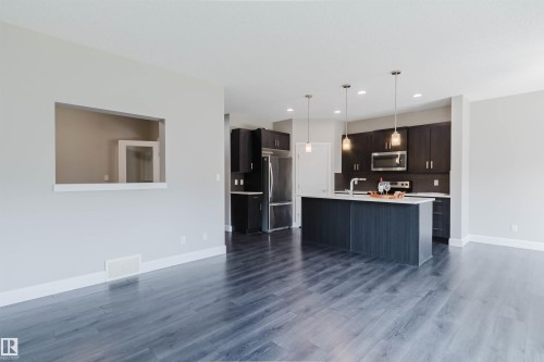Open-concept living area with wood-finish flooring extending into the kitchen - 2839 Koshal Crescent, Edmonton, AB - Indoor Photo Showing Kitchen