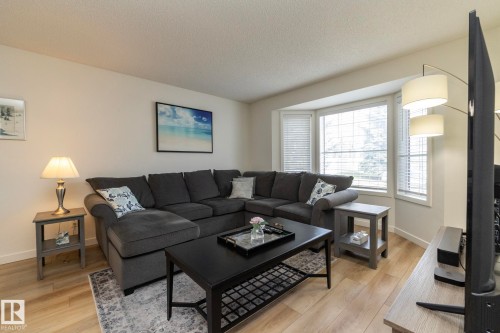Laminate wood-finish flooring throughout - 25 1904 Mill Woods Road Road, Edmonton, AB - Indoor Photo Showing Living Room