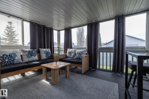 Enclosed sunroom with full-height windows and slatted blinds - 25 1904 Mill Woods Road Road, Edmonton, AB - Indoor Photo Showing Living Room