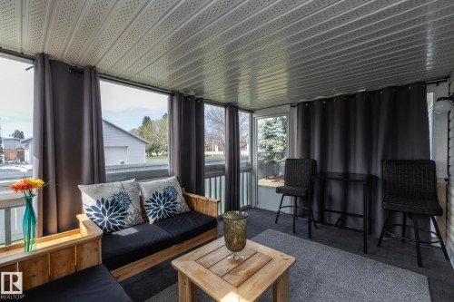 Enclosed porch featuring a slatted ceiling, multiple windows, and a textile floor covering - 25 1904 Mill Woods Road Road, Edmonton, AB - 