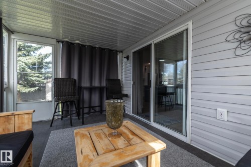 Enclosed patio featuring durable siding, a screened window, and a sliding glass door - 25 1904 Mill Woods Road Road, Edmonton, AB - Outdoor With Deck Patio Veranda With Exterior