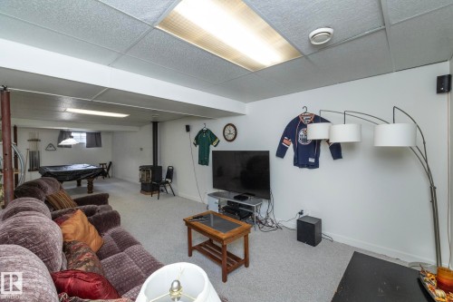 Spacious basement recreation area featuring light-toned carpeting, white walls, and a drop ceiling with integrated lighting - 25 1904 Mill Woods Road Road, Edmonton, AB - Indoor