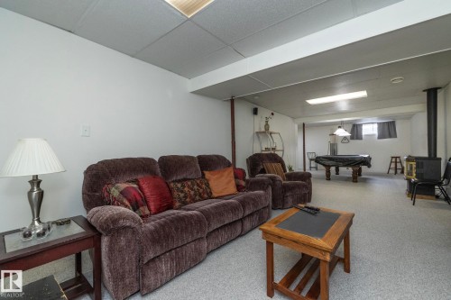 Finished basement space featuring light-colored flooring, white walls, and a drop ceiling - 25 1904 Mill Woods Road Road, Edmonton, AB - Indoor