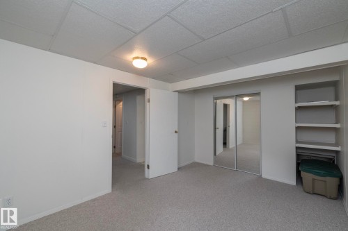 Carpeted room with white walls, drop ceiling, and flush mount lighting - 25 1904 Mill Woods Road Road, Edmonton, AB - Indoor Photo Showing Other Room