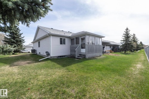 Rear exterior featuring a screened-in porch with a wood-finish deck and lattice skirting - 25 1904 Mill Woods Road Road, Edmonton, AB - Outdoor