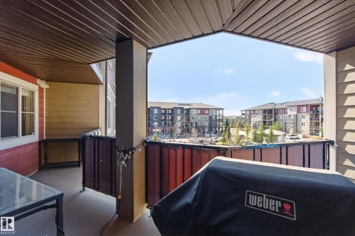 Covered balcony featuring a textured ceiling, a concrete floor, and painted siding - 314 3211 James Mowatt Trail Sw, Edmonton, AB - Outdoor With Deck Patio Veranda With Exterior