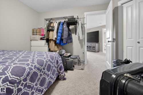 Bedroom featuring light gray wall paint, textured ceiling, and neutral carpet flooring - #314 3211 James Mowatt Tr Sw Sw, Edmonton, AB - Indoor Photo Showing Bathroom