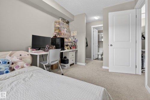 Bedroom featuring light neutral wall paint, light-colored carpet flooring, white trim, and a white two-panel interior door - 314 3211 James Mowatt Trail Sw, Edmonton, AB - Indoor Photo Showing Bedroom