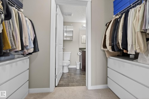 Walk-in closet with built-in white drawer units and overhead wire shelving - 314 3211 James Mowatt Trail Sw, Edmonton, AB - Indoor With Storage