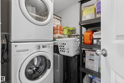Dedicated utility space featuring a stacked washer and dryer unit - 314 3211 James Mowatt Trail Sw, Edmonton, AB - Indoor Photo Showing Laundry Room