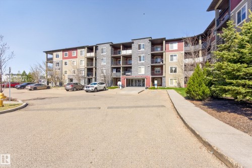 Multi-story residential building featuring a stone and siding exterior, multiple balconies, and a main entrance with a canopy - 314 3211 James Mowatt Trail Sw, Edmonton, AB - Outdoor With Facade
