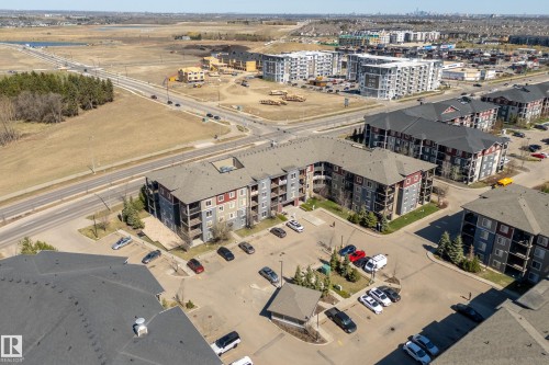 Multi-story residential complex featuring contemporary exterior finishes, private balconies, and dedicated surface parking - 314 3211 James Mowatt Trail Sw, Edmonton, AB - Outdoor With View