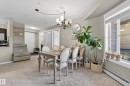 Open-concept dining area featuring a chandelier, a large window, and light-colored carpeting - 314 3211 James Mowatt Trail Sw, Edmonton, AB  - Indoor Photo Showing Dining Room 